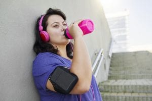 Female athlete drinking water after really hard workout